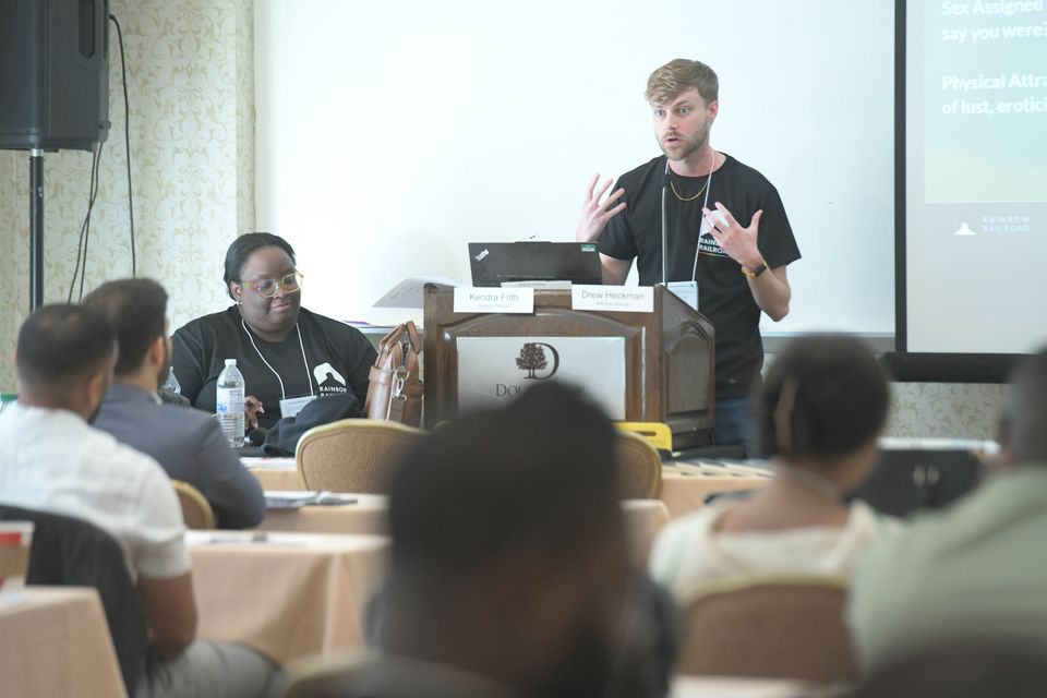 Drew speaking at conference podium